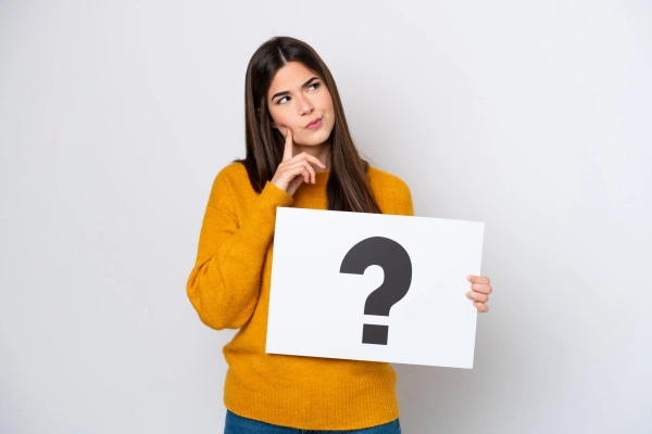 Woman holding a question mark board representing customer queries and FAQs for Buildwell gypsum products easy answers to Buildwell ceiling and interior product FAQs