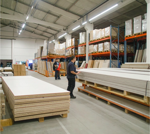 Workers handling gypsum boards in Buildwell warehouse highlighting large stock availability and efficient supply chain as part of our identity