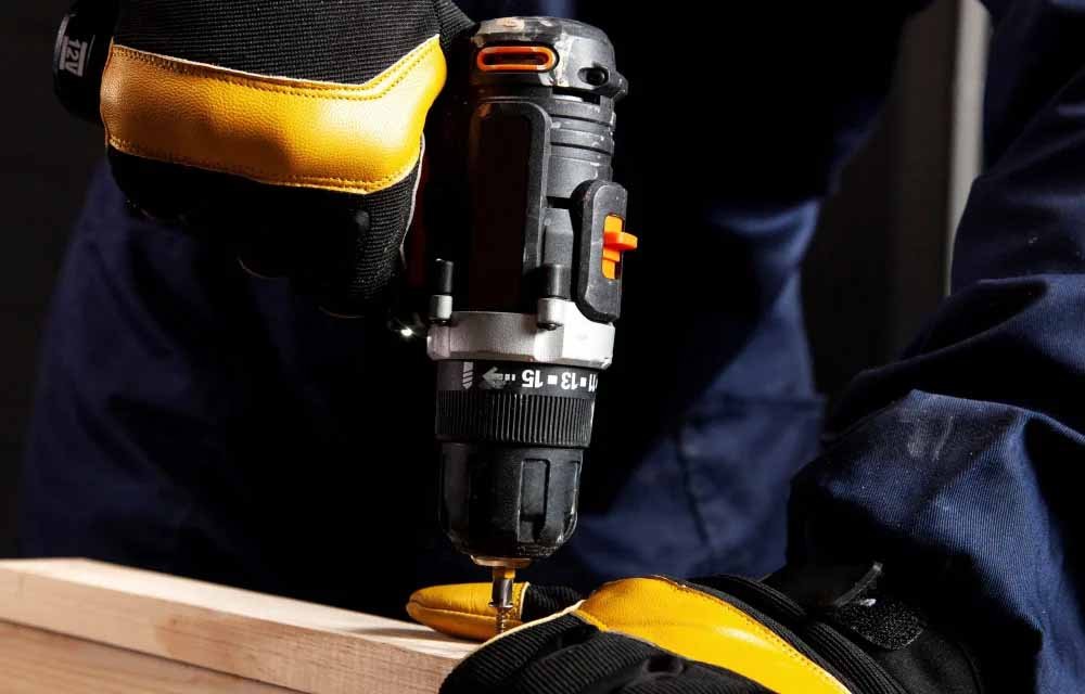 Technician using Buildwell Screwdriver Machine with gloves for accurate fastening on wooden surface