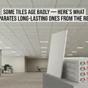 Suspended grid ceiling tiles installed in a modern office space with stacked acoustic ceiling tile panels displayed in the foreground