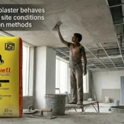 Workers applying gypsum plaster on an interior ceiling at a construction site with packaged gypsum plaster, showing the Best Gypsum Plaster Brand in India